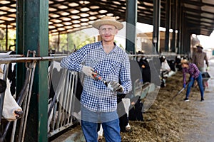 Young focused male farmer in a cowshed, fills a syringe with a vaccine