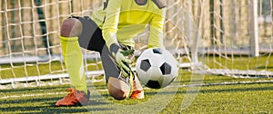 Young Football Goalkeeper Catching Soccer Ball. Soccer Goalie in Action Saving Ball in a Goal