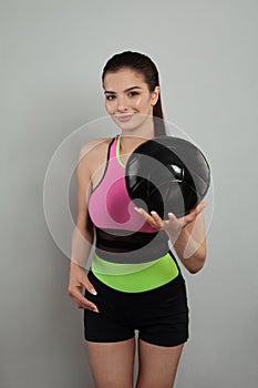 Young football player woman over gray wall background