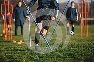 Young Football Players Running Slalom and Jumping Over Poles