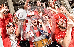 Young football supporter soccer fans cheering with flag and confetti