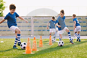 Young footballer improving dribbling skills on turf football training pitch