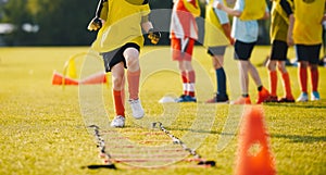Young Footballer in Yellow Sportswear at Training Session on Grass Soccer Field