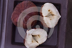 Young forest nuts on top of the black solid chocolate close