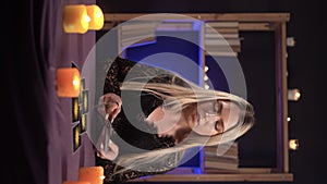 Young Fortune teller reading a future by tarot cards in the light of candle concept.