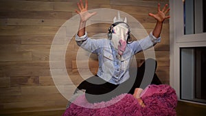 Young freaky woman in funny unicorn mask