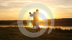 Young free couple dancing at sunset on beach. Happy guy and girl waltz in evening in a summer park. Enamored man and