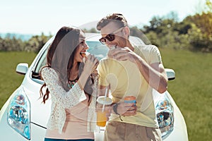 Young and free couple having little picnic near their car