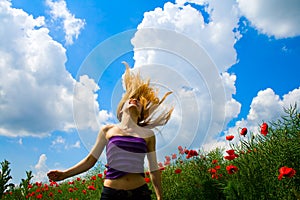 Young free happy woman in poppy field