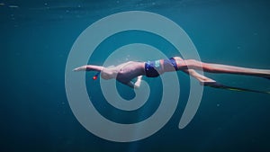 Young freediver, man swims underwater with fins, diving into water to depth