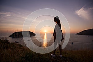 Young freedom woman enjoy ocean sunset on mountain peak