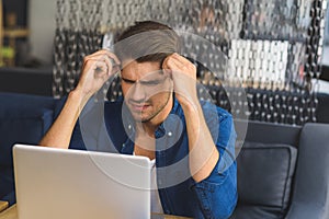 Young freelancer in front of a laptop trying to think