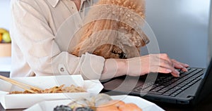 Young freelancer woman tasting asian food at the workplace.