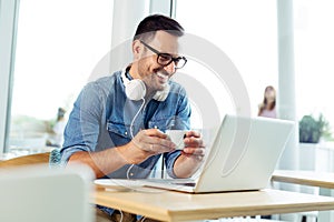 Young freelancer working on laptop at the coffeehouse photo