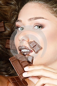 Young fresh beautiful woman eating chocolate, beauty female face