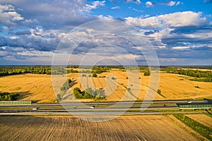 Young fresh spring yellow fields and a large highway before heavy tidal rain