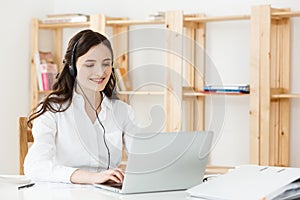 Young friendly operator woman agent or business woman with headsets working in a call centre.