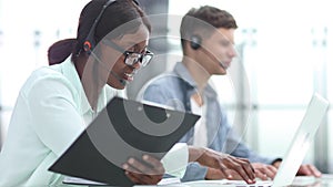 Young friendly operator woman agent with headsets working in a call center