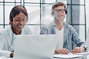 Young friendly operator woman agent with headsets working in a call center