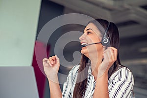 Young friendly operator woman agent with headsets working in a call centre.