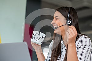 Young friendly operator woman agent with headsets working in a call centre.