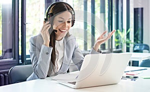 Young friendly operator woman customer service agent with phone VOIP headsets working in a call center