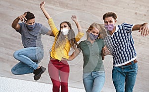 Young friends dancing together while wearing face mask outdoor - Happy people having fun in city after corona virus quarantine