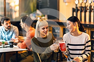 Young friends drinking craft beer in pub