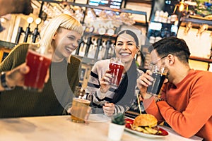 Young friends drinking craft beer in pub