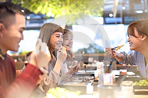 friends eating hot pot in the restaurant