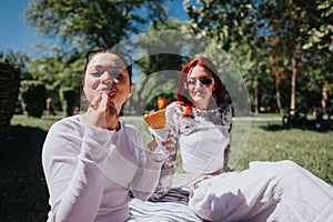 Young friends enjoying ice cream on a sunny day in the park, carefree and happy