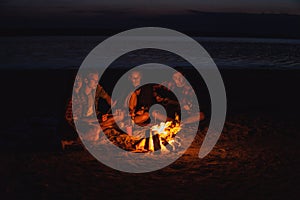 Young friends have picnic with bonfire on the beach