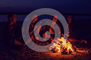 Young friends have picnic with bonfire on the beach