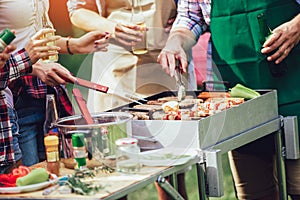 Friends having fun grilling meat enjoying barbecue party, close up