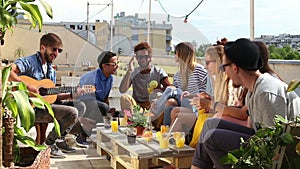 Young friends at party on rooftop terrace