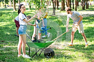 young friends planting new trees and volunteering