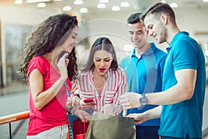 Young Friends Shopping In Mall Together