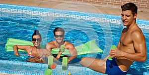 Young friends in swimming pool smiling