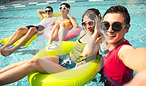 Young friends taking selfie at the swimming pool