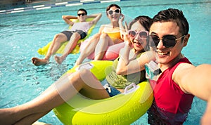 young friends taking selfie at the swimming pool