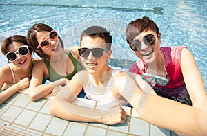 young friends taking selfie at the swimming pool