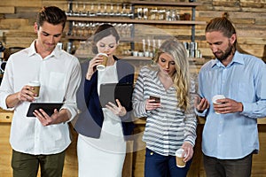 Young friends using digital tablet and mobile phone