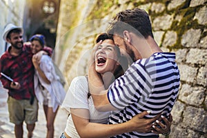 Young friends walking in city old town center on summer vacation