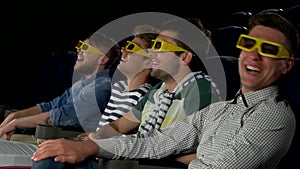 Young friends watching a film at the cinema. Close