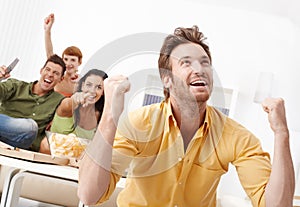 Young friends watching tv at home