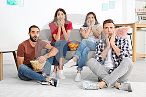 Young friends watching TV in room