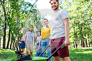 young friends with wheelbarrow and new trees volunteering