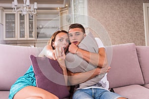 Young Frightened Couple Watching Scary Film on TV