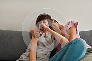 Young frightened lesbian girls watching TV on sofa