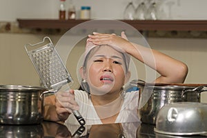 Young frustrated Asian woman in domestic chores stress - lifestyle home portrait of beautiful overwhelmed and stressed Korean girl
